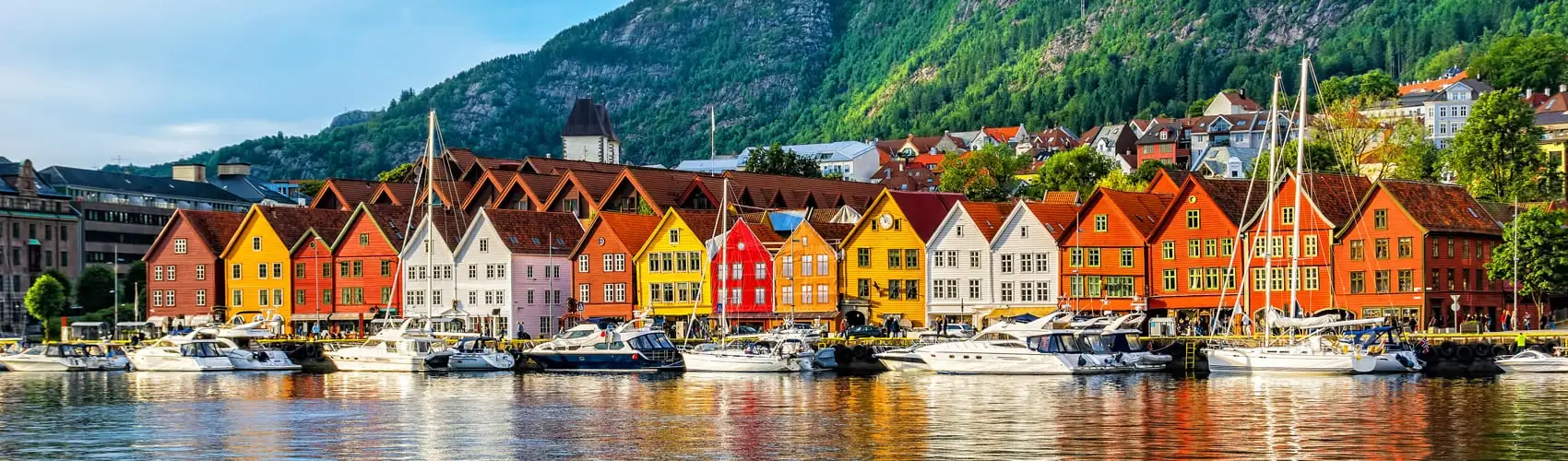 Die bunten Hansehäuser von Bryggen in Bergen, Norwegen, am Hafen mit Bergen im Hintergrund